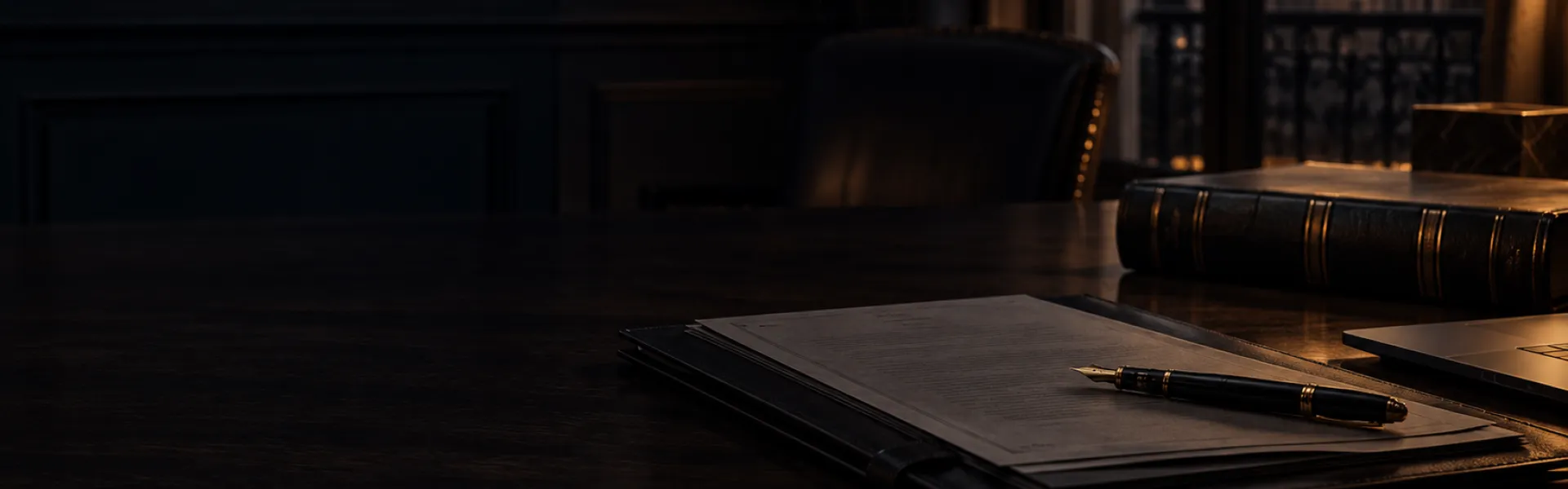 Carpeta y pluma sobre una mesa de trabajo oscura